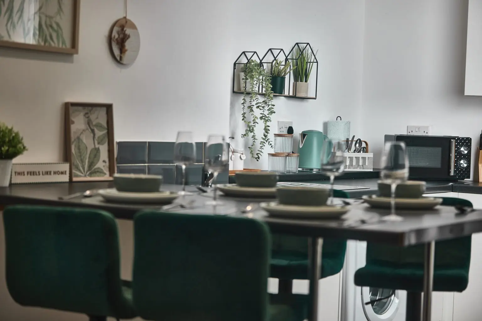 Modern kitchen diner with dark green velvet chairs and a table set for dinner, interior photography in Liverpool by Captured By Luke Media
