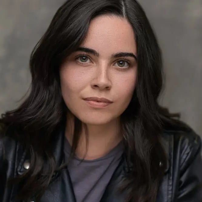 Actress in a black leather jacket photographed against a dark studio backdrop for a Liverpool casting headshot