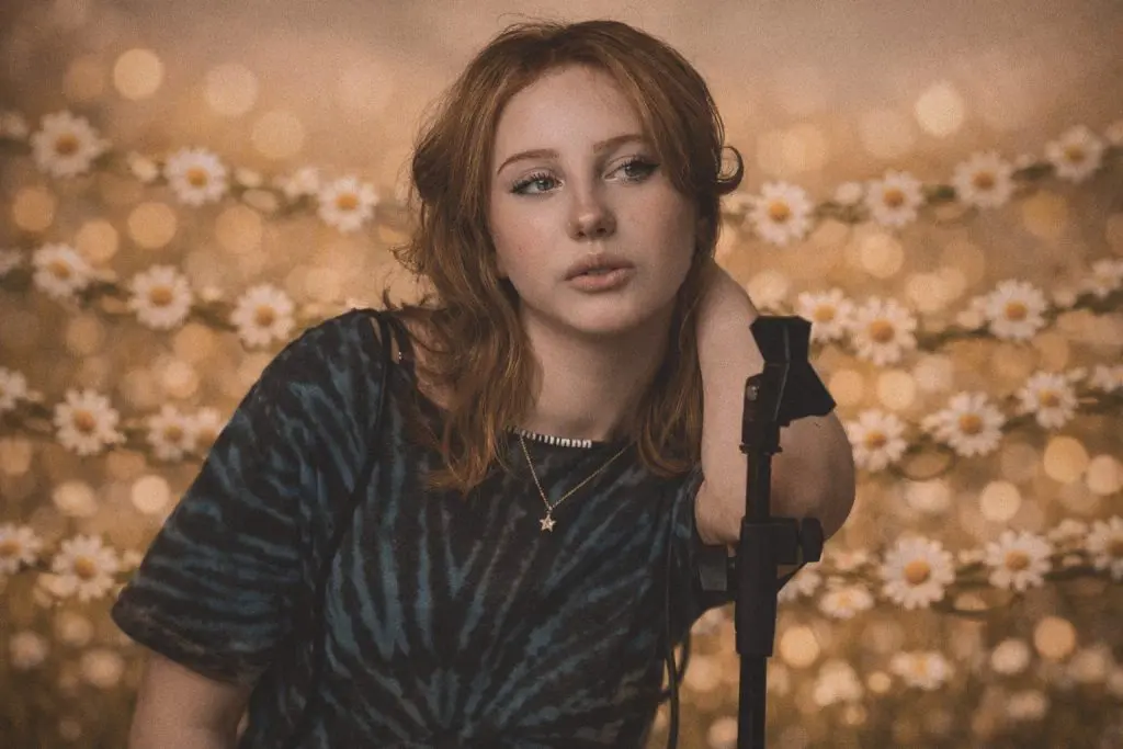 Singer with a microphone stand framed by daisies and warm bokeh