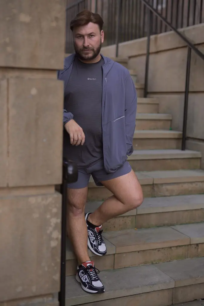 Content creator in a purple co-ord leaning on a handrail on stone steps