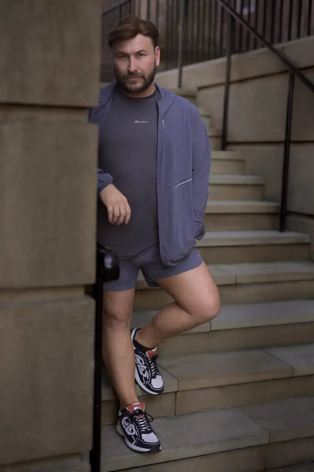 Man in a purple co-ord posed on stone steps for a personal branding shoot
