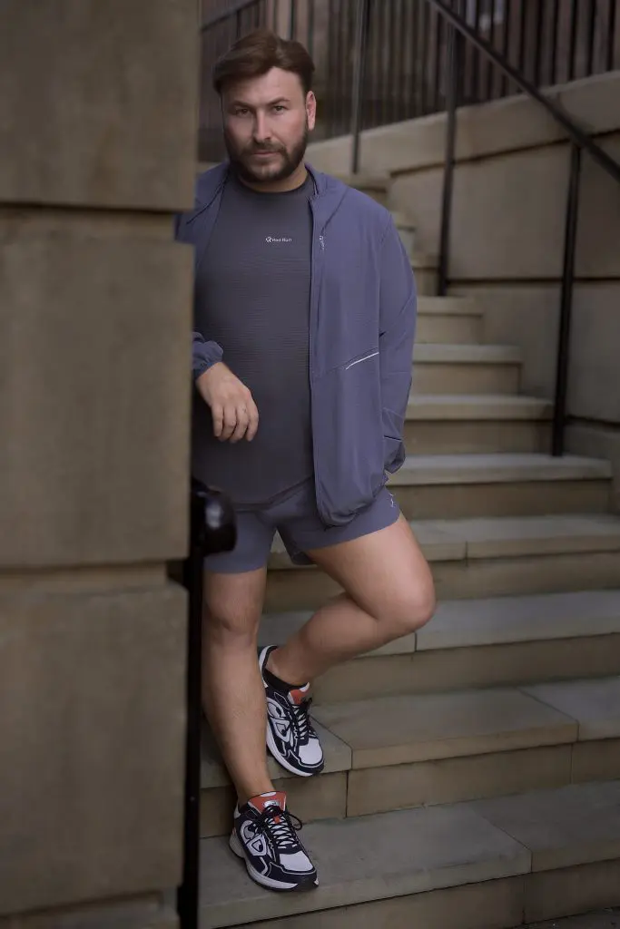 Man in a purple co-ord posed on stone steps for a personal branding shoot
