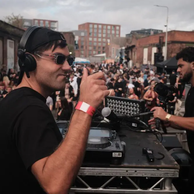 DJ Huzey playing to a packed crowd at an open air event in the Baltic Triangle, Liverpool