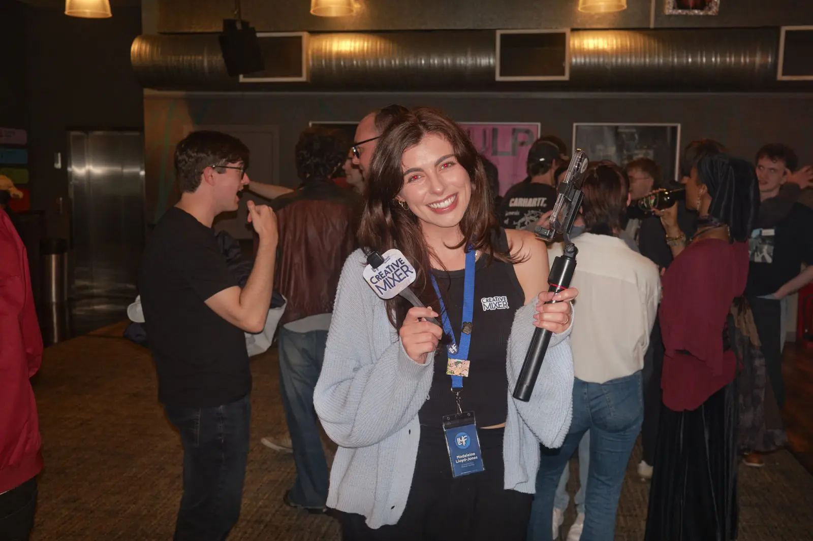 Smiling host holding a Creative Mixer microphone and phone gimbal among guests at the Let’s Make Films social mixer, FACT Picture House Liverpool