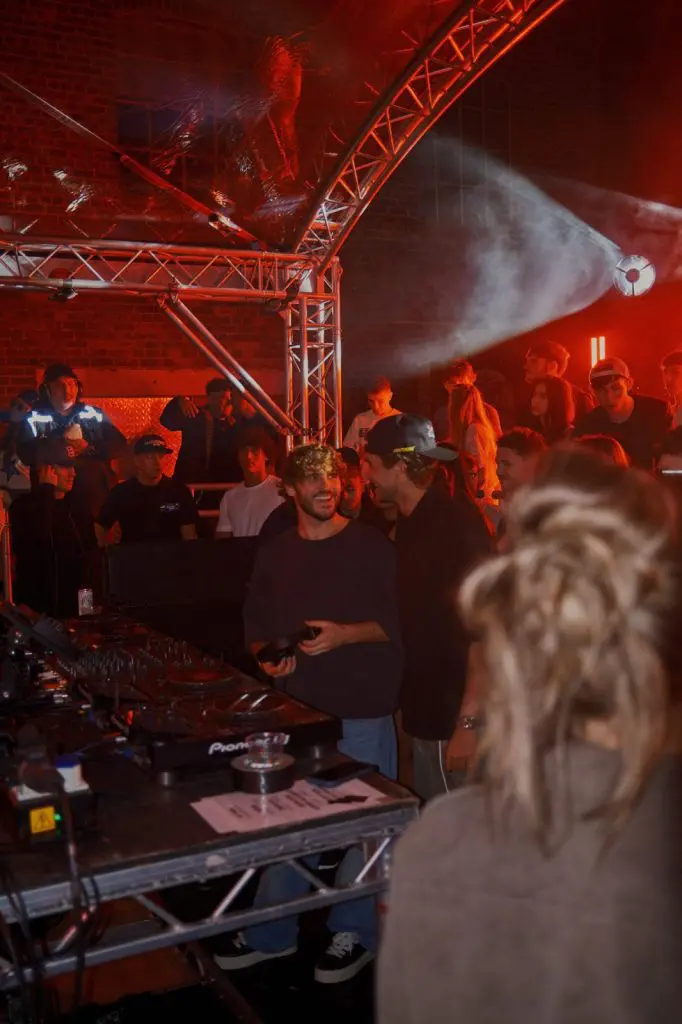 Crowd around the DJ booth under red light at COCO Open Air in Liverpool