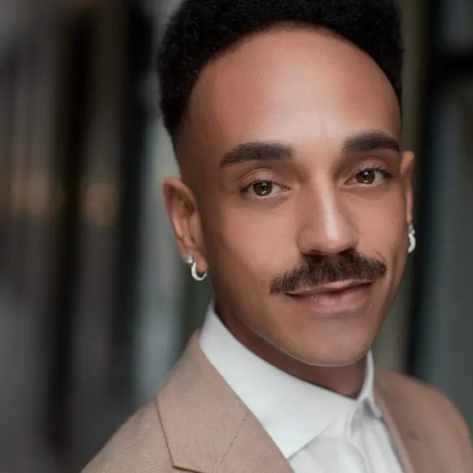 Corporate headshot of a man in a beige suit and white shirt