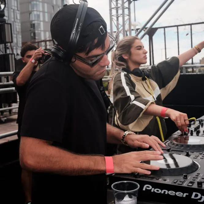 DJ Huzey on the decks with the crowd behind him at COCO Open Air, Liverpool