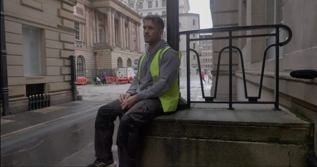 A worker taking a break outside a Liverpool workplace, filmed for a recruitment video
