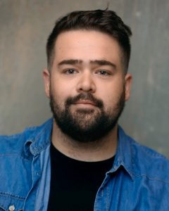 Actor Shaun Fagan photographed against a grey studio backdrop in Liverpool
