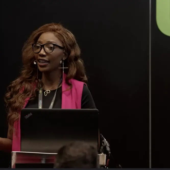 Speaker presenting at a lectern during a conference, filmed as part of event coverage in Liverpool