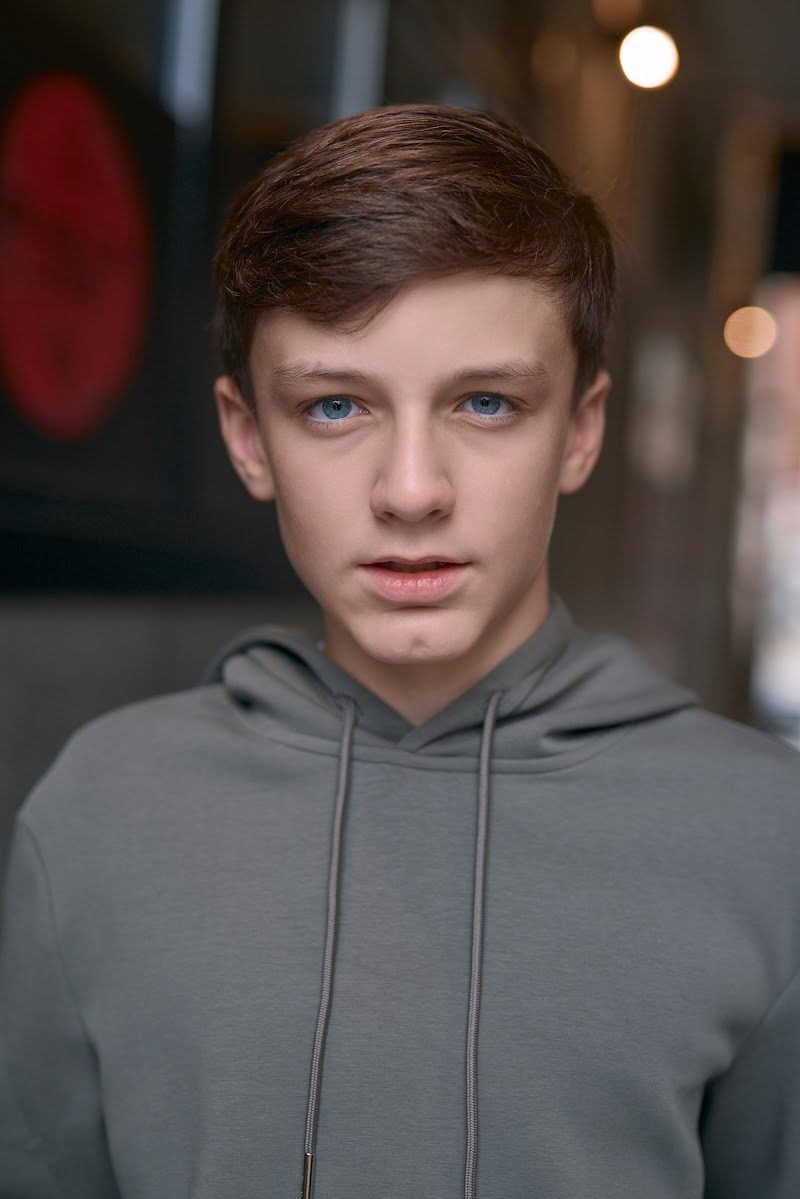 Young actor in a grey hoodie on location in Liverpool, serious and direct to camera