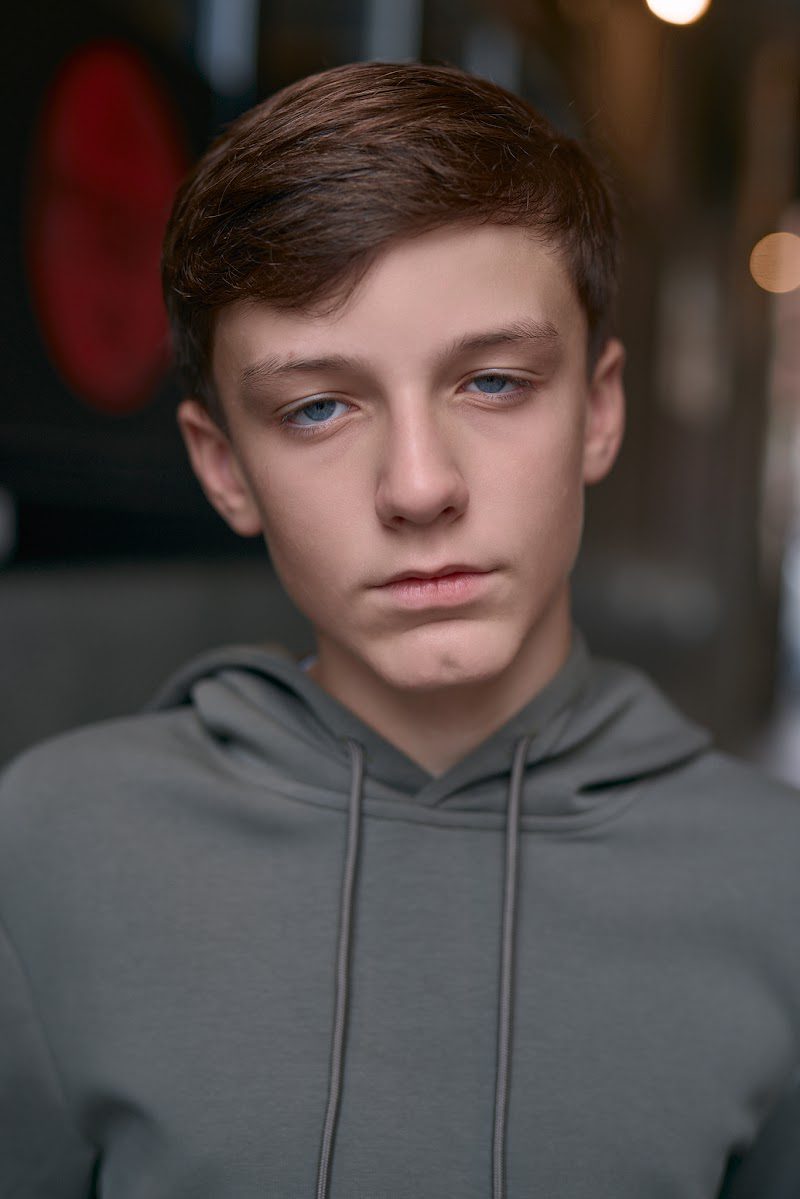Young actor in a grey hoodie on location in Liverpool, intense, still expression
