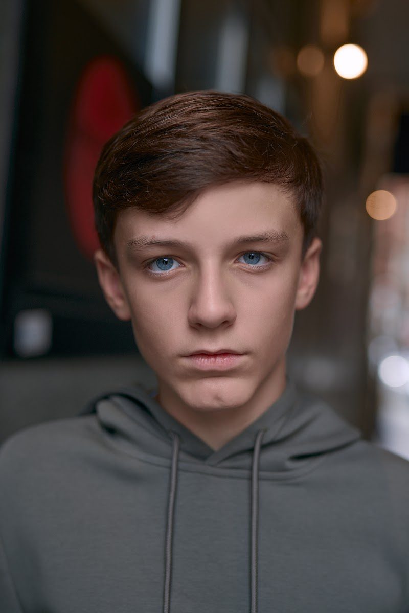 Young actor in a grey hoodie on location in Liverpool, neutral look, shallow depth of field