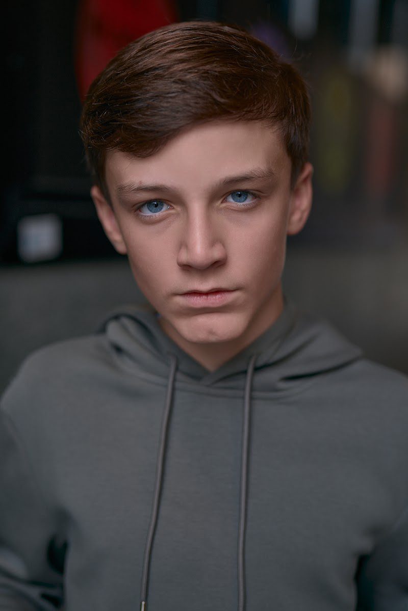 Young actor in a grey hoodie on location in Liverpool, serious expression, slight turn of the head