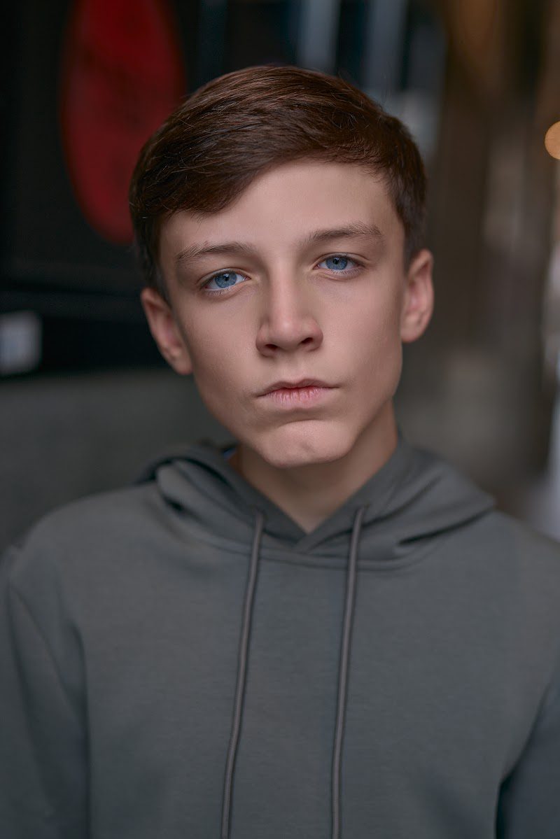 Young actor in a grey hoodie on location in Liverpool, neutral look, tight crop