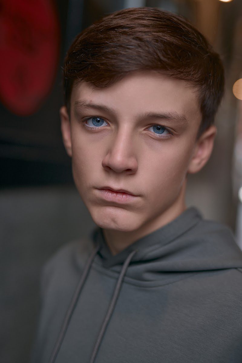 Young actor in a grey hoodie on location in Liverpool, direct, unsmiling look to camera