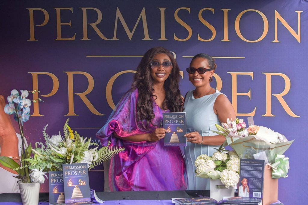 Author holding a copy of Permission to Prosper with a guest at her book launch and signing in Liverpool, event photography by Captured By Luke Media
